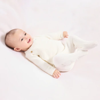 Newborn's wrap-around white and ecru knitted cardigan